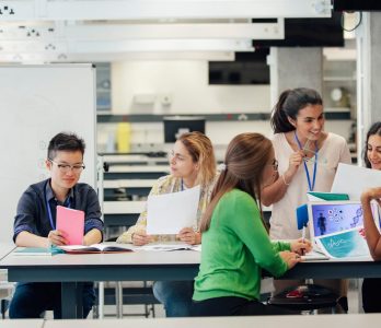 Formazione giovani talenti, studenti in un’aula universitaria si confrontano tra loro.